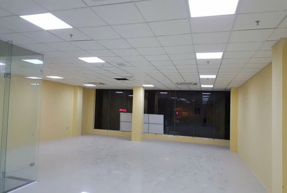 Empty office space at 666 Ngo Quyen Building with ceiling lighting and large glass windows